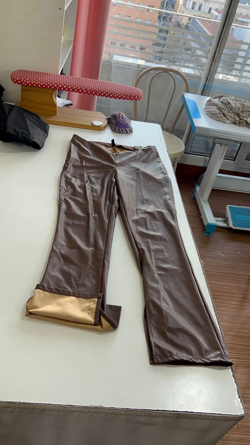 Pantalón de vinilo sobre la mesa de trabajo antes del ajuste de basta
