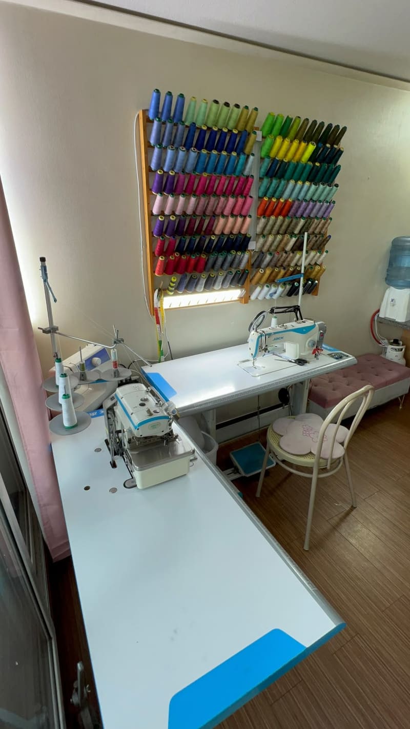Vista general del taller de costura de Costuras Adry, con hilos de colores y máquinas de coser